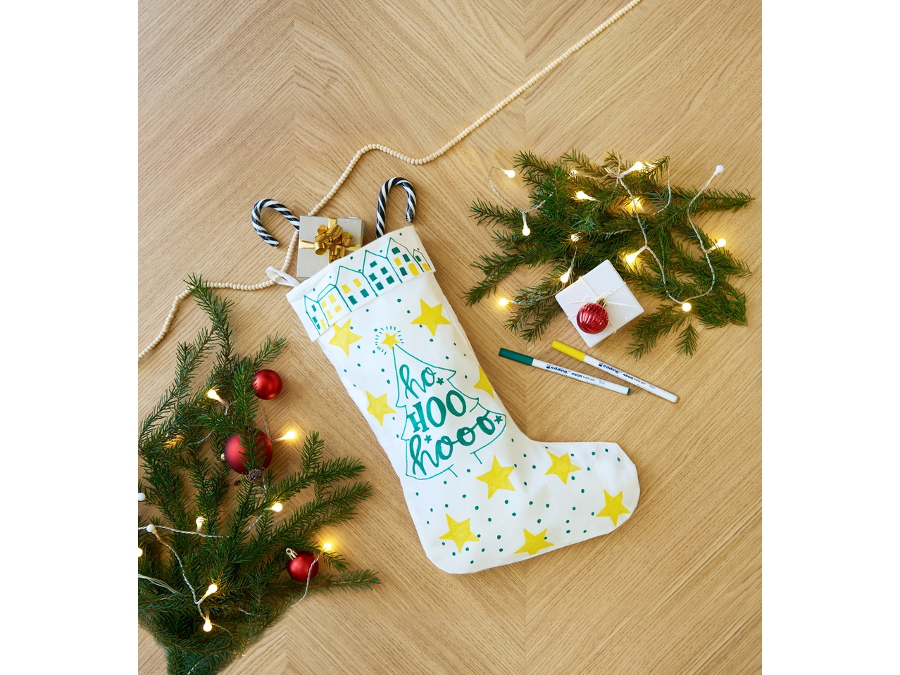 Balta Ziemassvētku zeķe ar rotājumiem, eglīte un tekstila marķieri