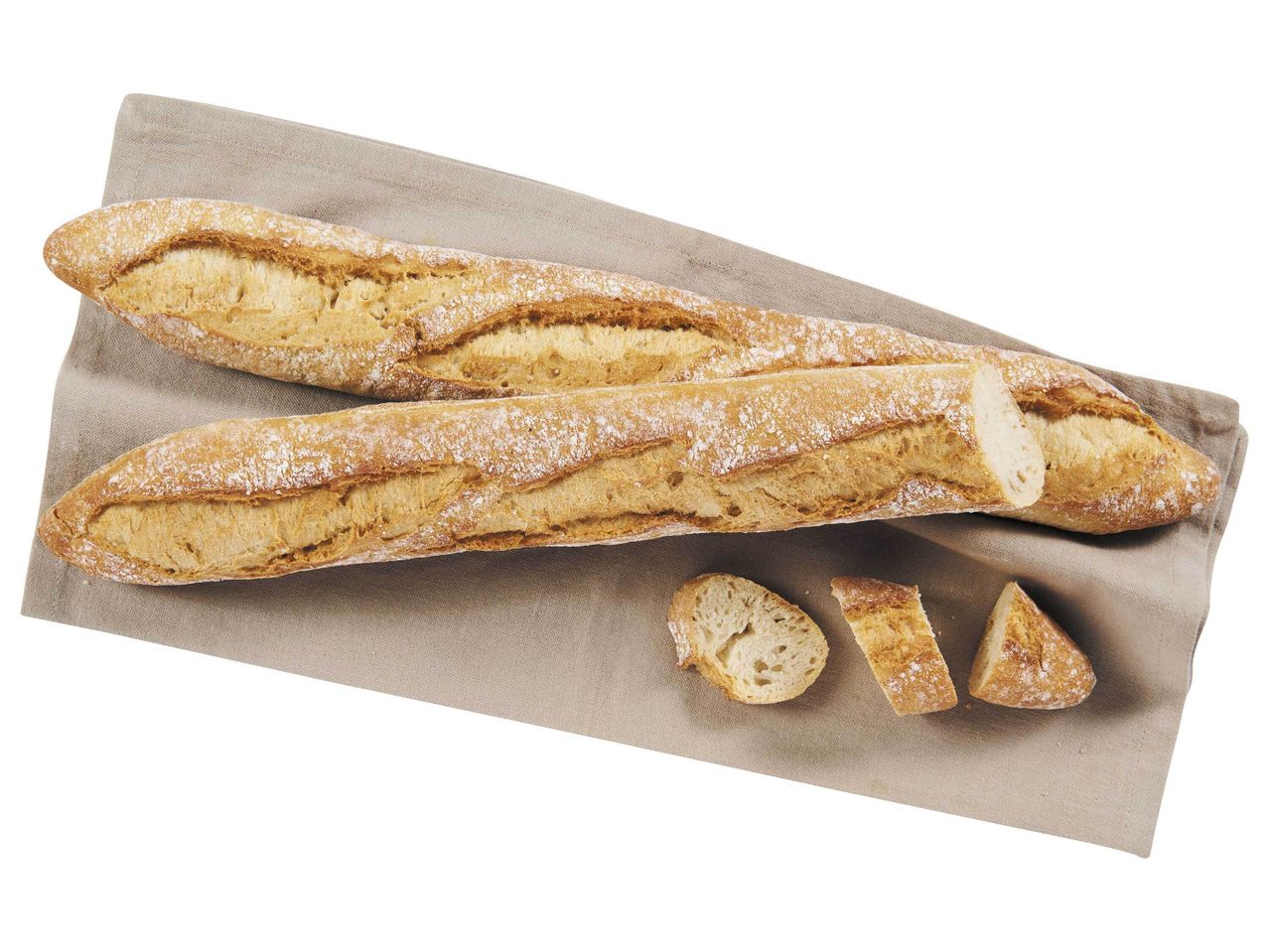 Deux baguettes et du pain coupé sur une serviette en lin.