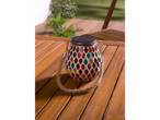 Uma lanterna solar colorida com mosaico em uma mesa de madeira.