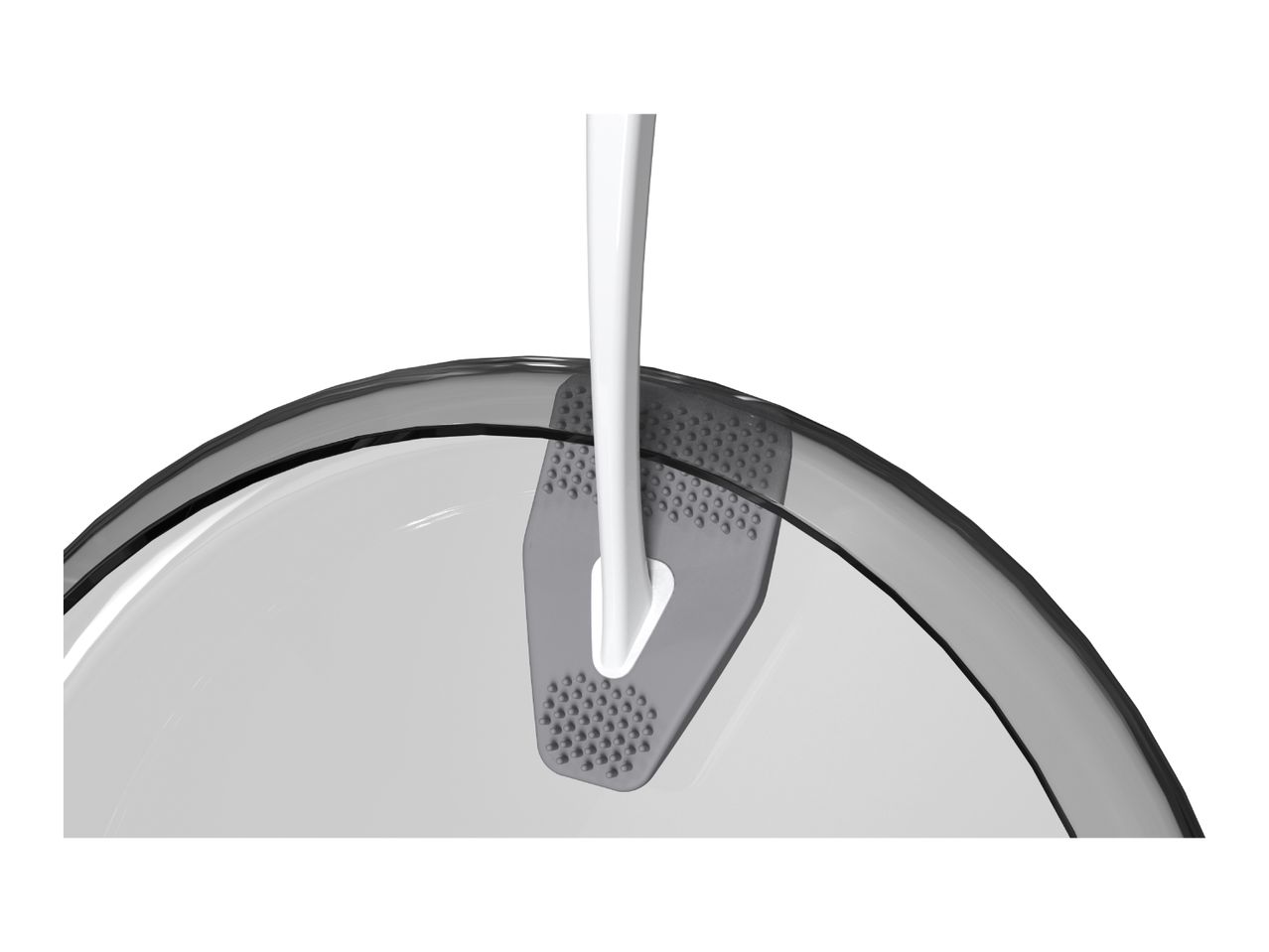 Close-up of a white and gray kitchen utensil with a textured surface, resting on a clear bowl.