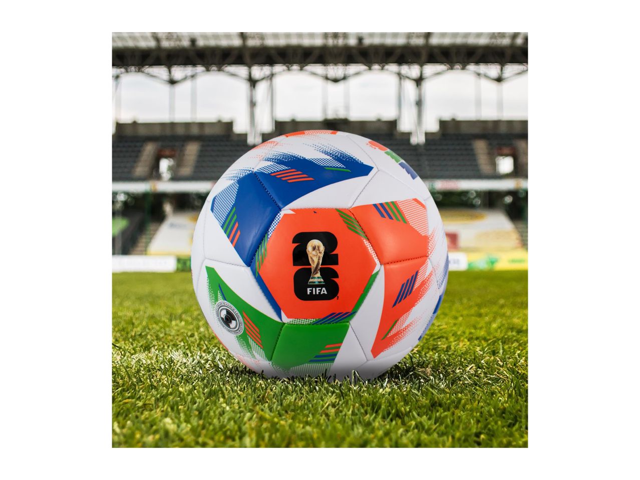 Soccer ball with colorful patterns on a green field in a stadium