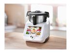 Monsieur Cuisine Smart food processor on a wooden table with a blurred kitchen background.