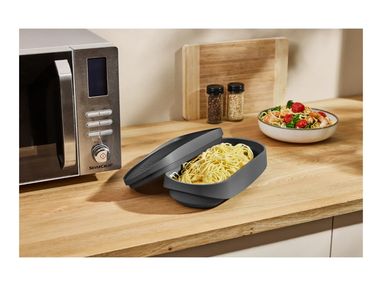 SilverCrest microwave and a container of noodles on a wooden kitchen counter.