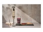 Silvercrest hand blender with whisk, measuring cup of berries, and baking paper on a counter.