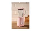 Pink blender with a glass jug on a wooden countertop with light pink tiled background