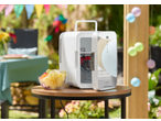 SILVERCREST® Mini Fridge with an open door revealing fruit, next to a bowl of fruit on a wooden table outdoors.