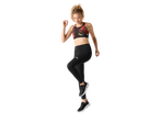 Woman in black leggings and a colorful sports bra, mid-stride, on a black background.
