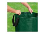 Hands inserting a flexible hoop into a green garden waste bag on grass.