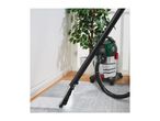A wet and dry vacuum cleaner being used to clean a grey carpet.