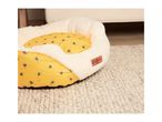 A Cath Kidston bee-themed pet bed sits on a light beige rug.