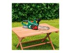 Parkside cordless chainsaw on a garden table.