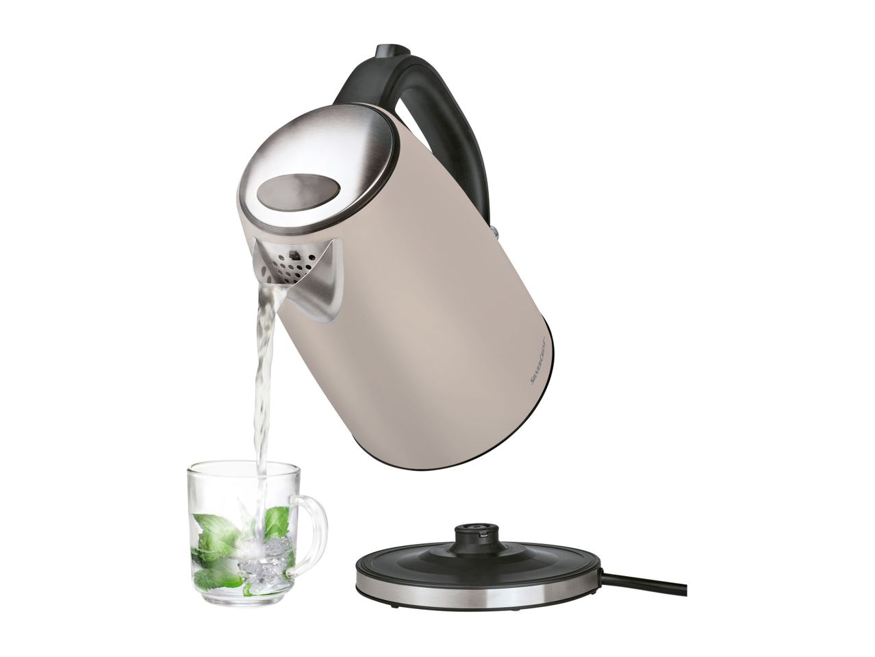 A beige electric kettle pours water into a glass, sitting on its base.