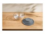 Set of clear glass mixing bowls nested together with a stack of gray silicone lids.