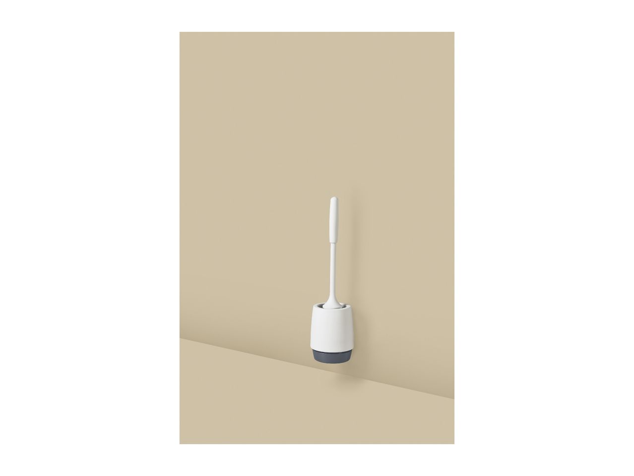 White toilet brush with a grey base in a modern bathroom setting.