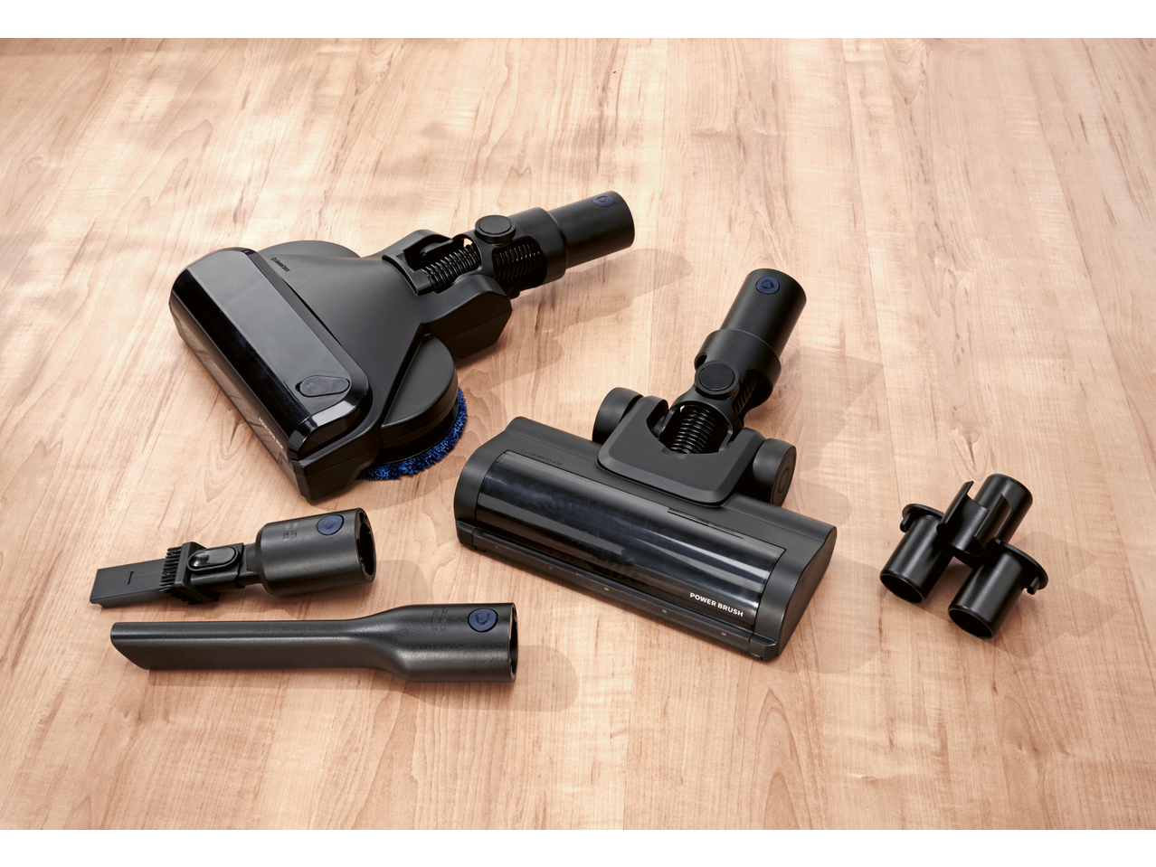 SILVERCREST® Cordless Cyclone Handheld Vacuum Cleaner with various attachments on a wooden floor.