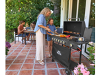 Family grilling with a Grillmeister 6 burner gas barbecue on a patio.