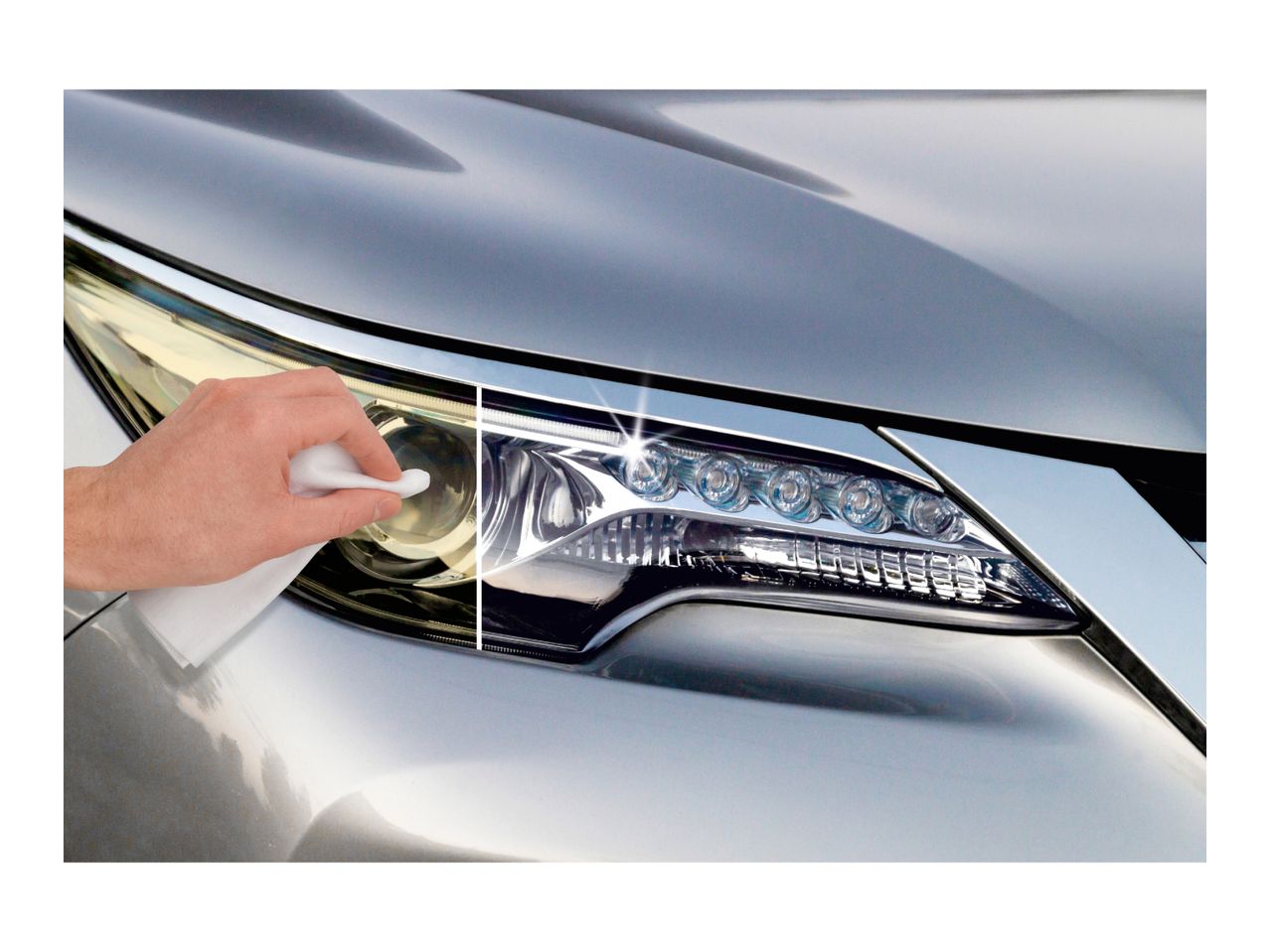 A hand wiping a car headlight, showing a before-and-after cleaning effect.