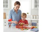 Mother and child preparing a lunchbox with fruit and vegetables, next to a water bottle.