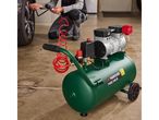 A person inflating a car tire with a green Parkside air compressor.