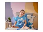 Girl in blue pyjamas with a cartoon character, sitting on a bed with matching bedding.