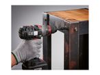 A person using a cordless drill to assemble a rustic metal and wood furniture piece.