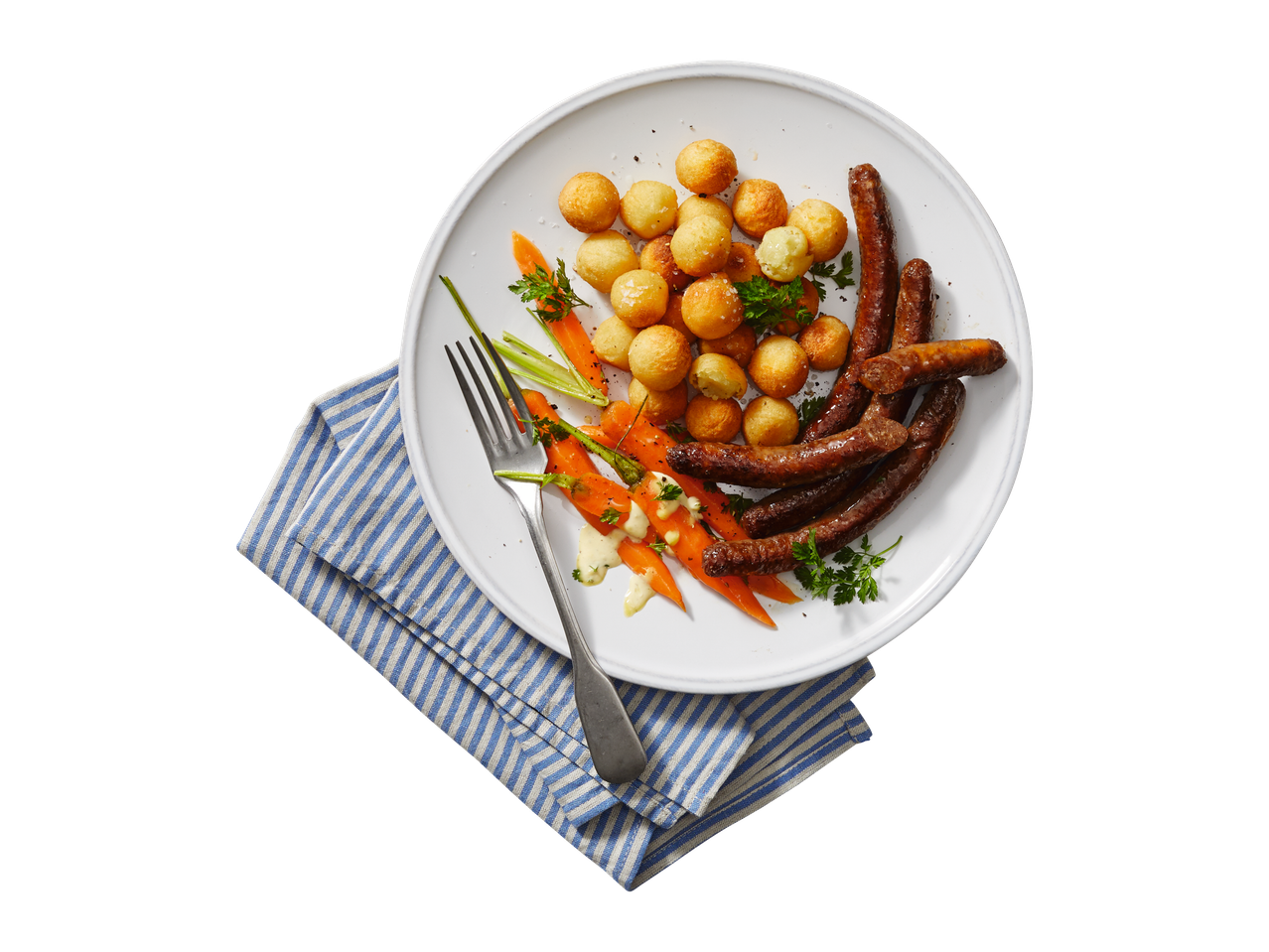 Worstjes, aardappelballetjes en wortels op een bord.