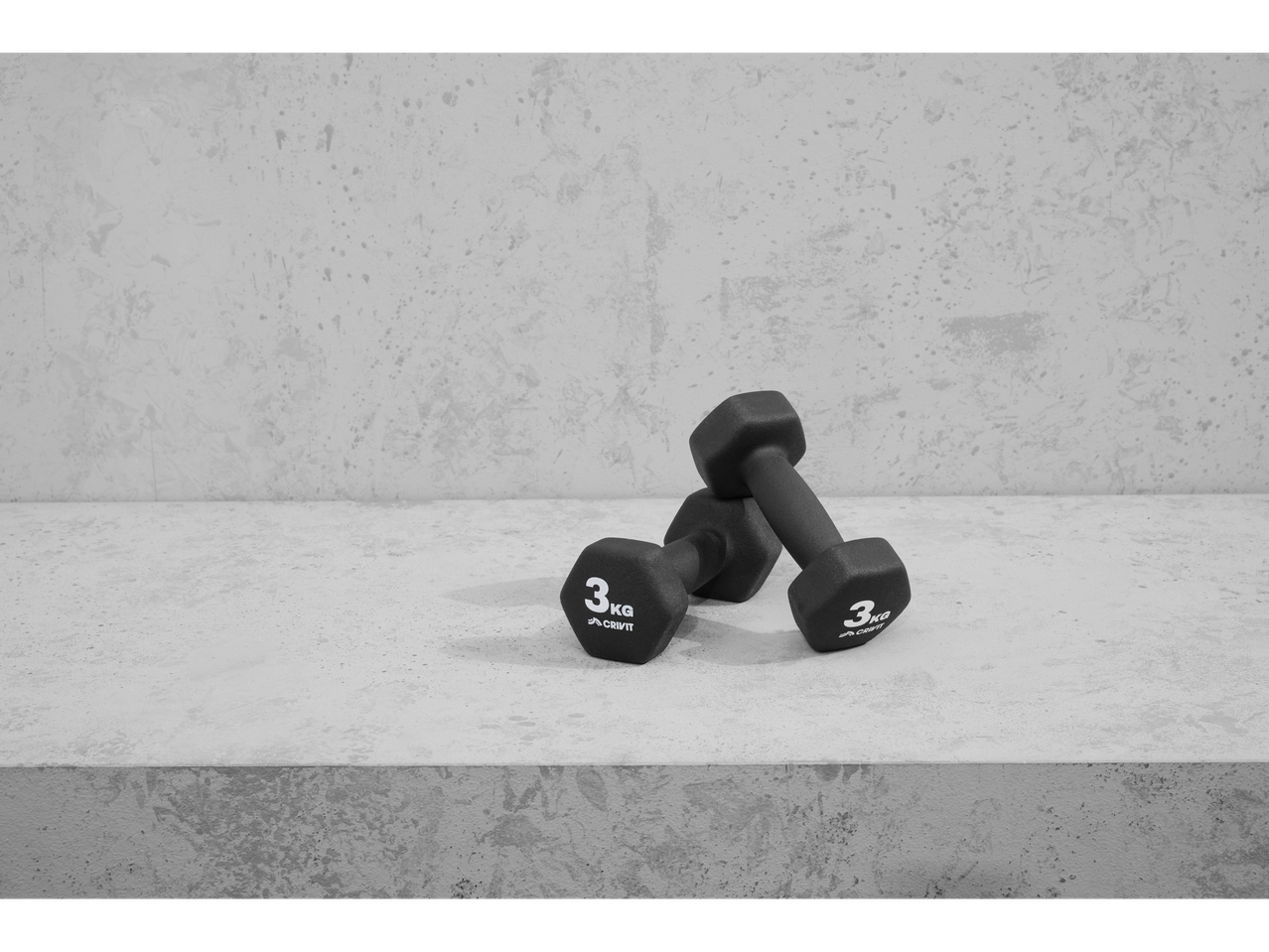 Two 3kg Crivit dumbbells on a concrete surface.