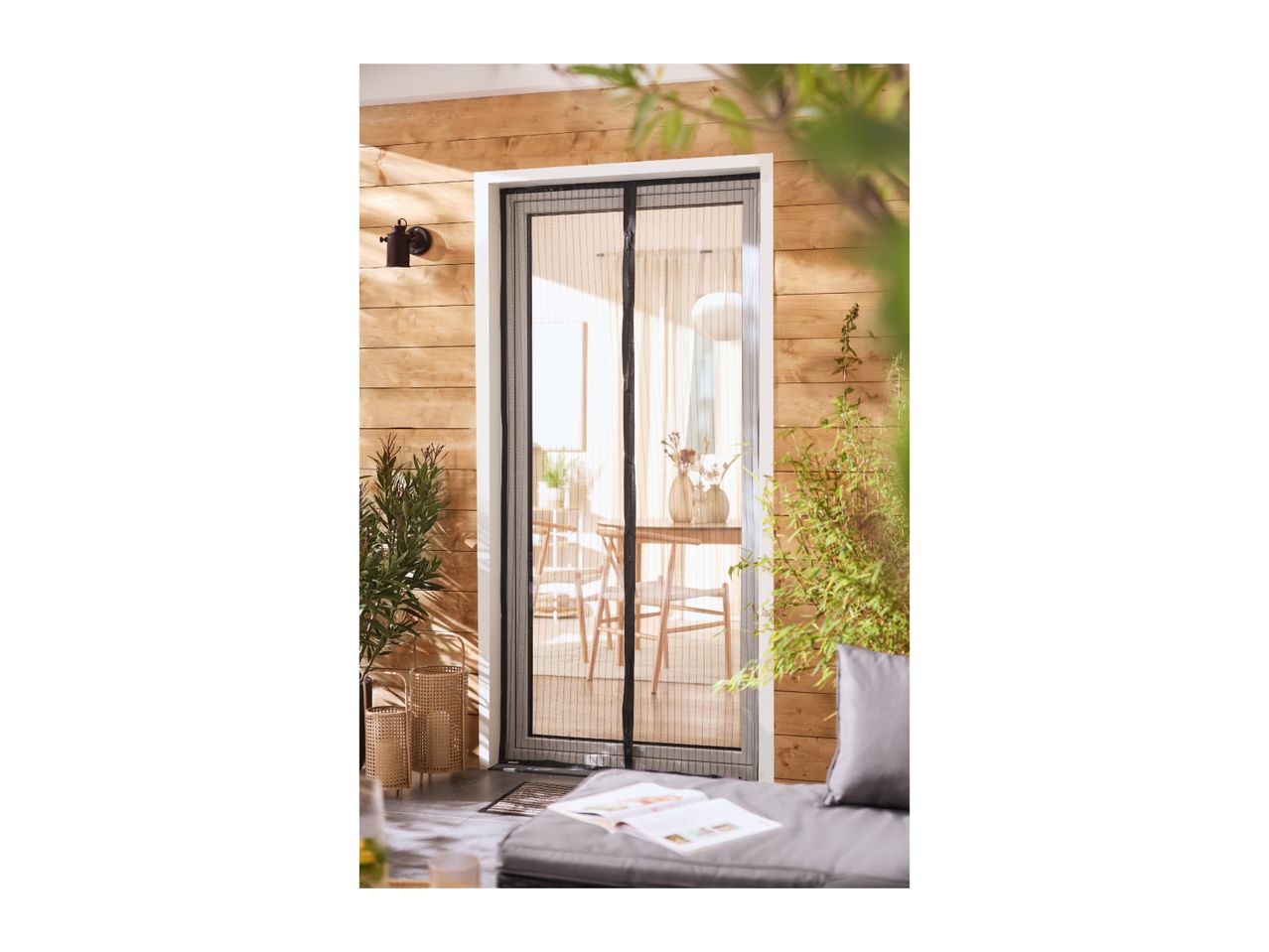 Magnetic fly screen door on a patio with wooden wall and outdoor seating.