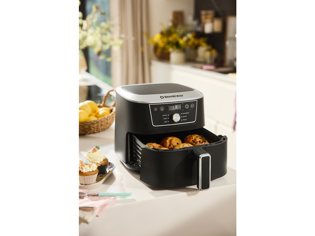 SILVERCREST hot air fryer with muffins and lemons in the kitchen.