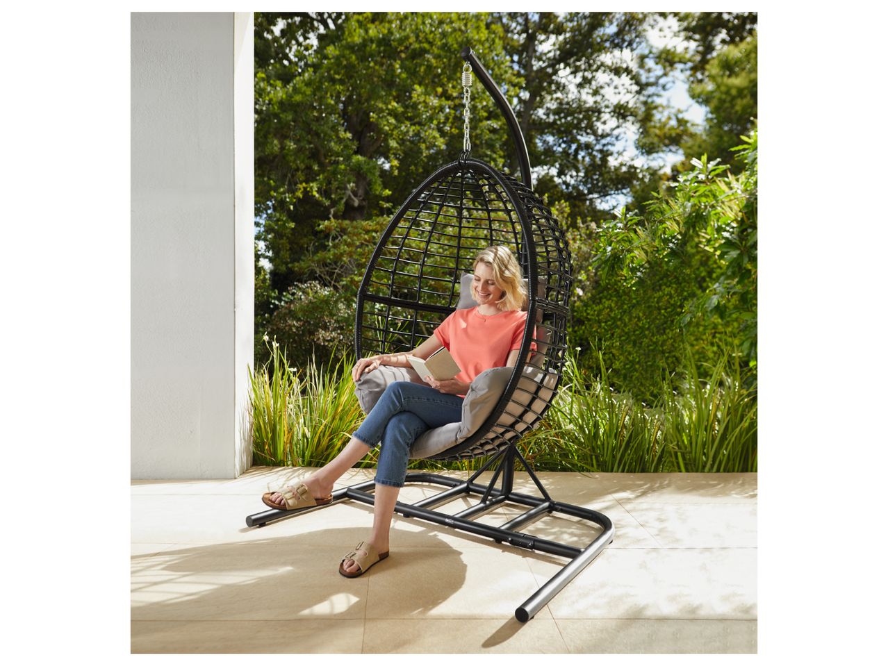 Woman relaxing in a garden hanging chair.