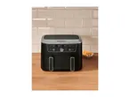 Black dual air fryer with digital display on a wooden counter with fries.