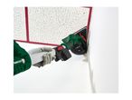 Person using a drywall sander with a long handle to sand a textured ceiling.