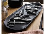 Manicure set with various tools on a black marble tray.