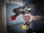 A person drilling into wood with a Parkside cordless drill, creating sawdust.