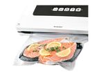A FoodSaver vacuum sealer machine sealing salmon fillets in a bag.