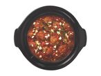 Slow cooker filled with meatballs in tomato sauce, topped with feta, parsley, and lemon zest.