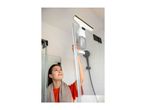 Woman cleaning a shower screen with a window vacuum cleaner.