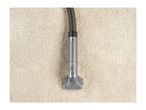 A vacuum cleaner attachment on a light-colored, textured carpet.