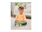 Baby girl playing with an interactive toy book on a white rug.