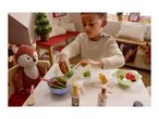 A child playing with a wooden toy grater and vegetables, with a fox plush toy nearby.