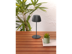 Candeeiro de mesa LED recarregável LIVARNO home numa mesa de madeira, com plantas ao fundo.