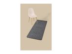 A white chair and a grey geometric patterned runner rug on a beige background.