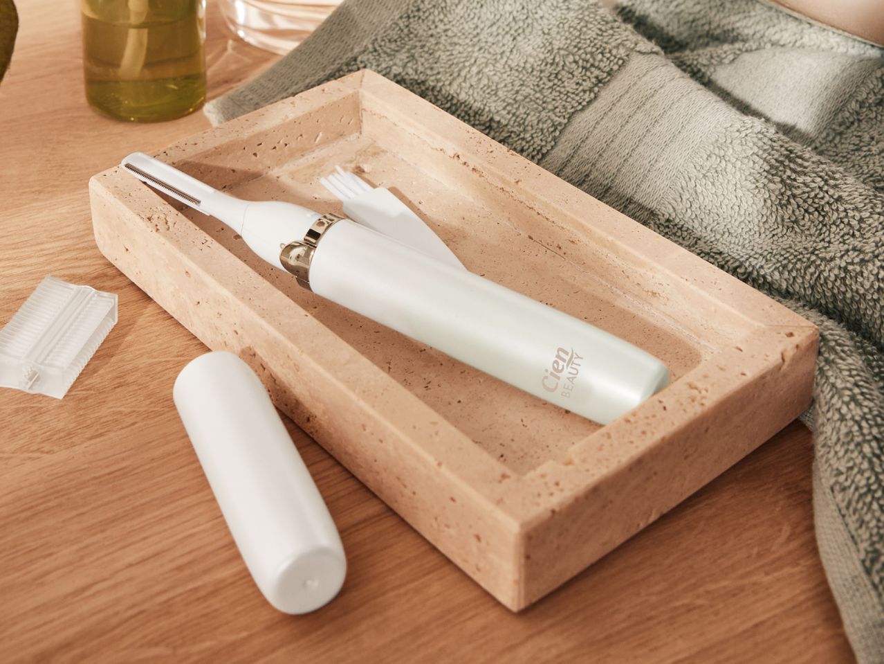 Cien Beauty facial hair trimmer set in a stone tray with a green towel