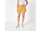 Shorts amarelos de algodão com cordão e tênis brancos.