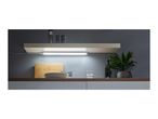 Kitchen shelf with under-cabinet lighting, spices, plates, and a plant.