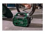 Portable air compressor with a built-in flashlight, inflating a bicycle tire in a garage.