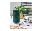 Green macrame cord spool next to a black wire basket being wrapped with the thread.
