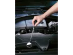Mão usando um espelho de inspeção para verificar o motor de um carro.