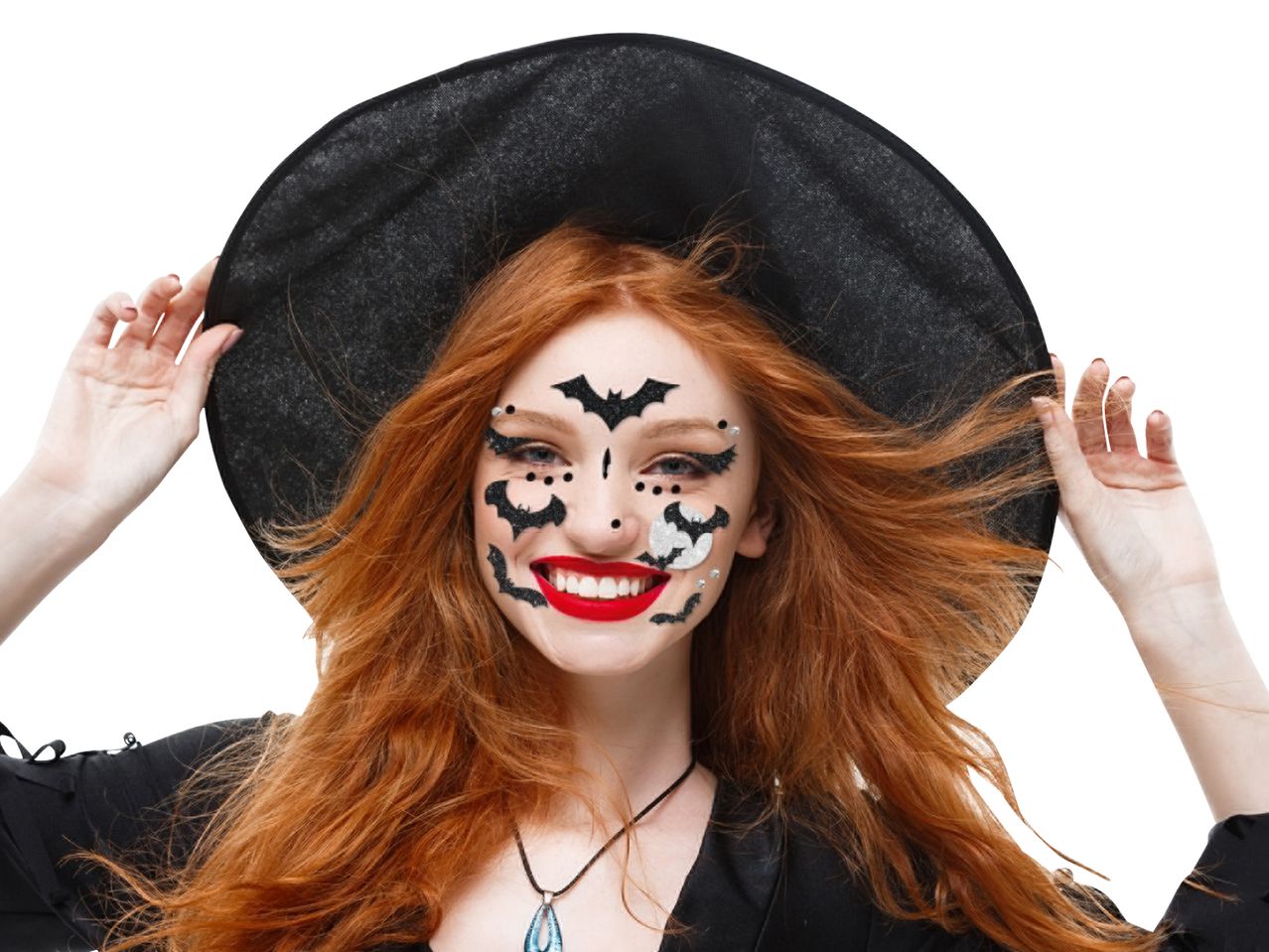 Woman with red hair and witch hat, wearing Halloween face makeup with bats