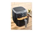 Black and silver air fryer with potato wedges on a wooden countertop